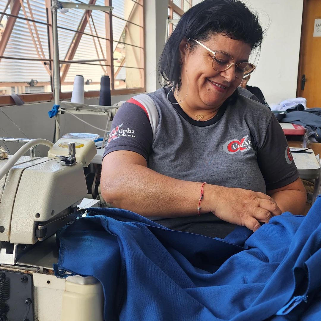 costureira da UniAlpha trabalhando em uniforme azul na produção própria em Sorocaba